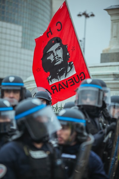 白天，红色的切·格瓦拉旗靠近一群警察